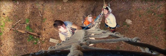 tres chicos subiendo por unas escaleras de cuerda